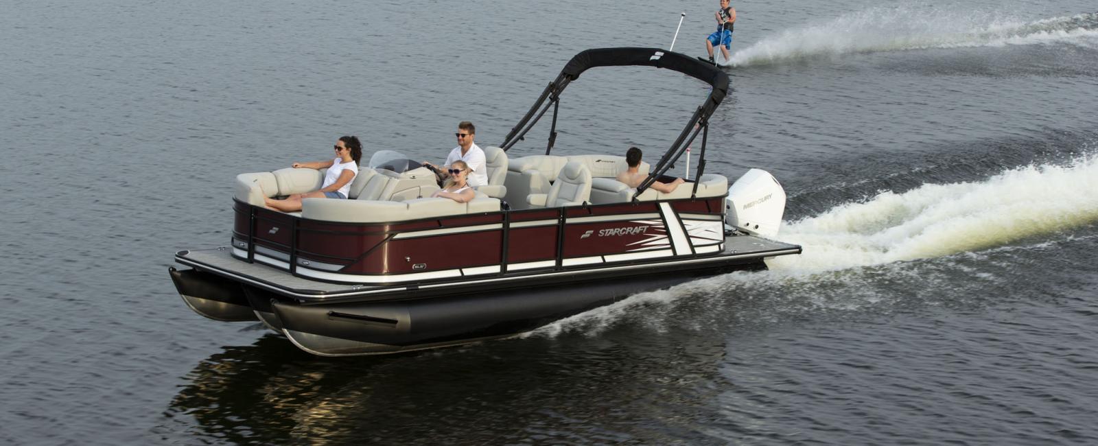 Expensive pontoon boat towing water skier