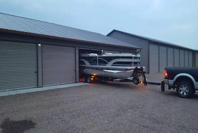 Pontoon boat being towed out of garage on trailer