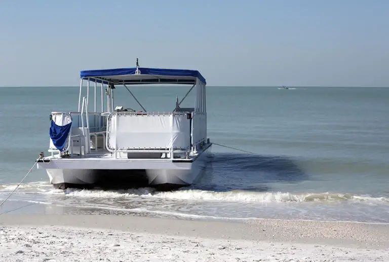 Pontoon boat anchored on saltwater beach